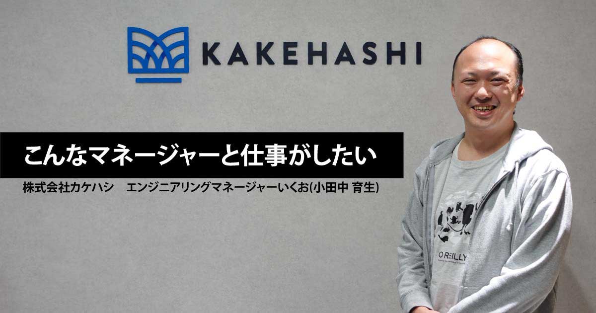 株式会社カケハシのロゴの前に立つ小田中 育生さん