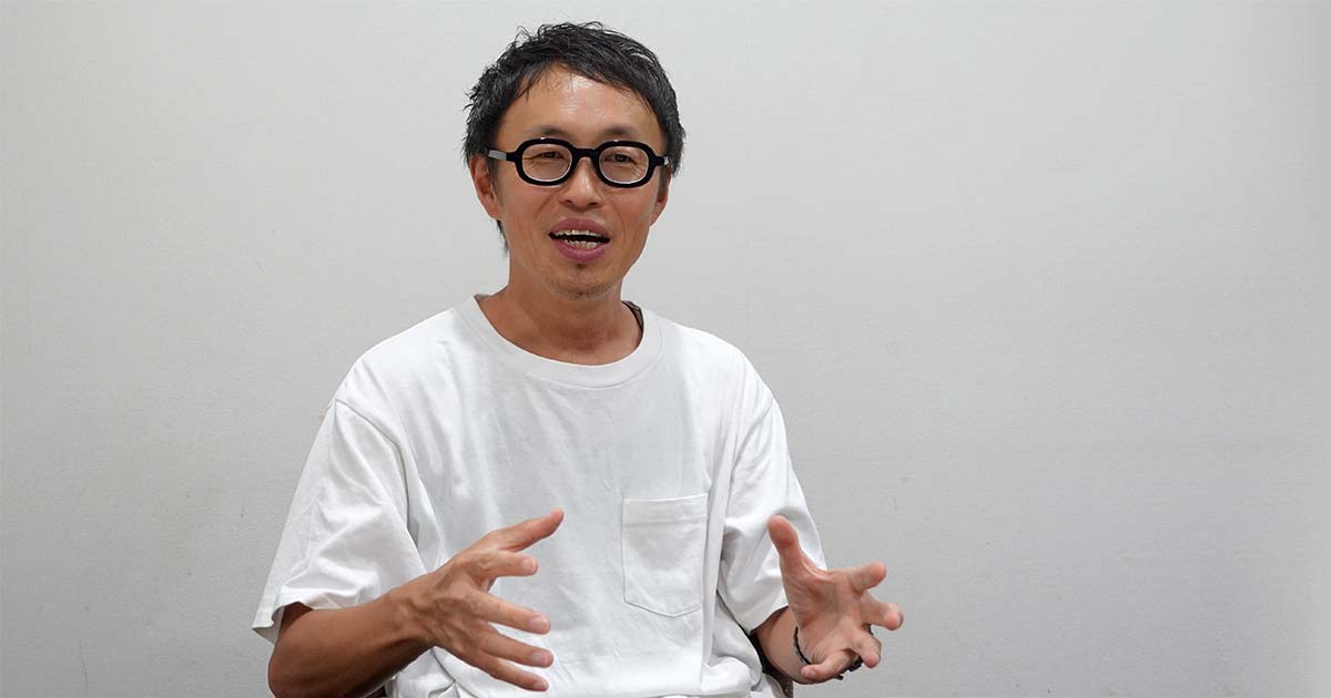 両手を使って身振り手振りを入れながら話す、笑顔のこがねんさん