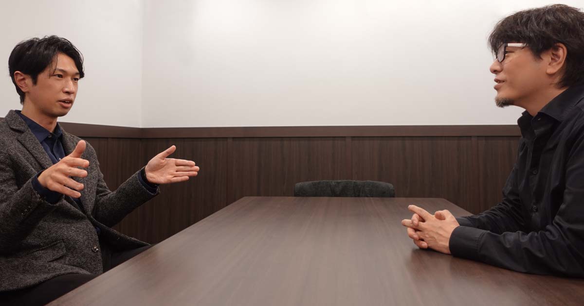 神谷さんとフジイがテーブルごしに座って楽しそうに話している写真