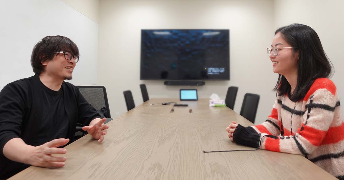 会議室で対面に座るフジイとハヤカワ五味さんの写真。笑いながら話している。