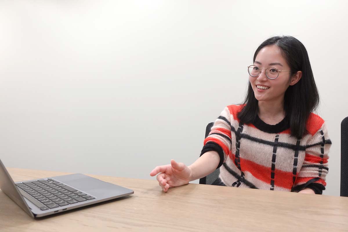 会議室のテーブルの前で身振り手振りを入れながら話すハヤカワ五味さん